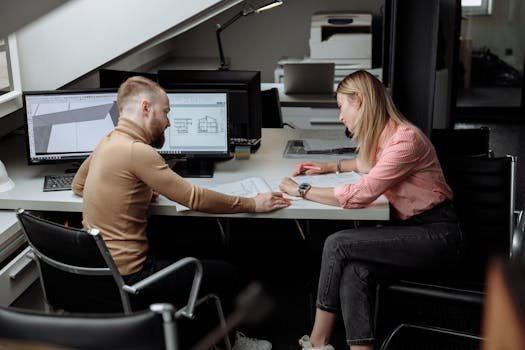 Two architects discuss plans in a contemporary office, focusing on project details.